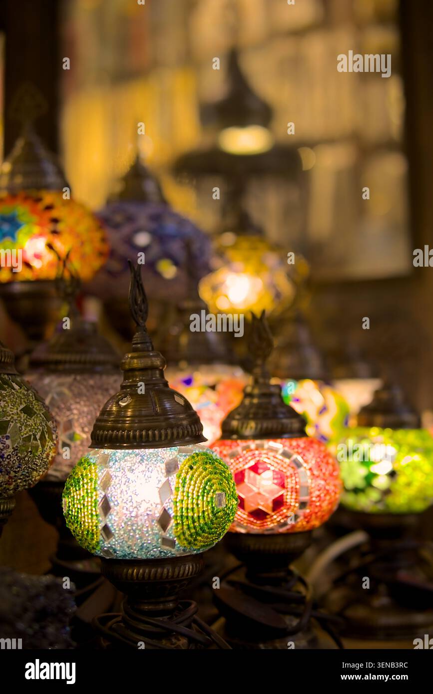 Primo piano di colorate lanterne a mosaico turco artigianali appese in un mercato tradizionale. Lampade decorative in vetro illuminate con luce calda e selezione Foto Stock