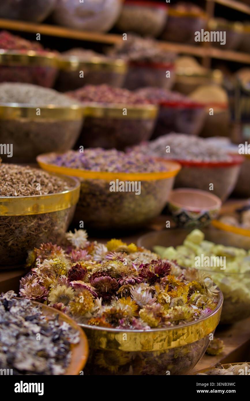 Colorato assortimento di fiori secchi e ingredienti botanici esposti in ciotole in un mercato tradizionale. Concetto di tisana, aromaterapia, Wellne Foto Stock