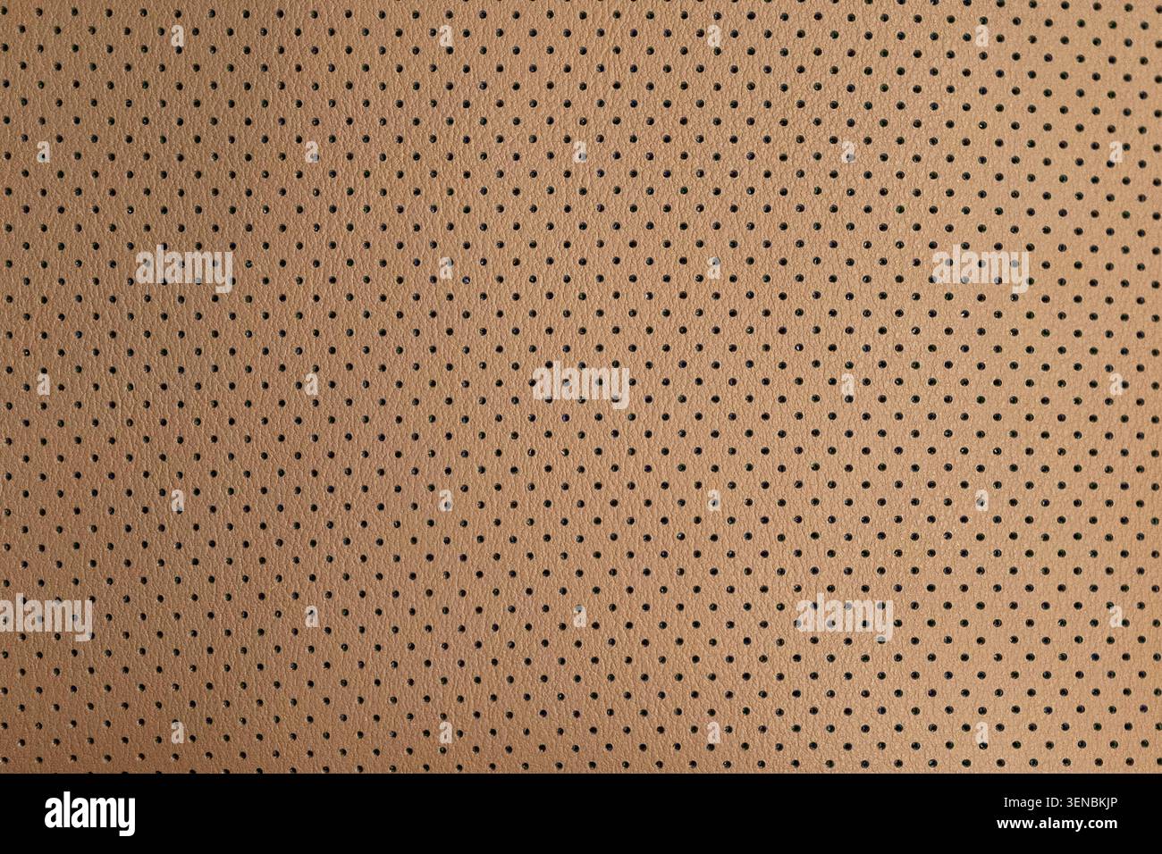 La texture in pelle traforata marrone crea un motivo elegante e senza cuciture per interni automobilistici, tappezzeria, sfondi alla moda e design moderno Foto Stock