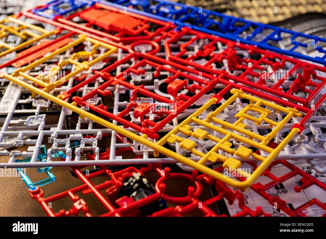 Parti di kit modello in plastica colorati e telai di assemblaggio in primo piano sullo sfondo Foto Stock