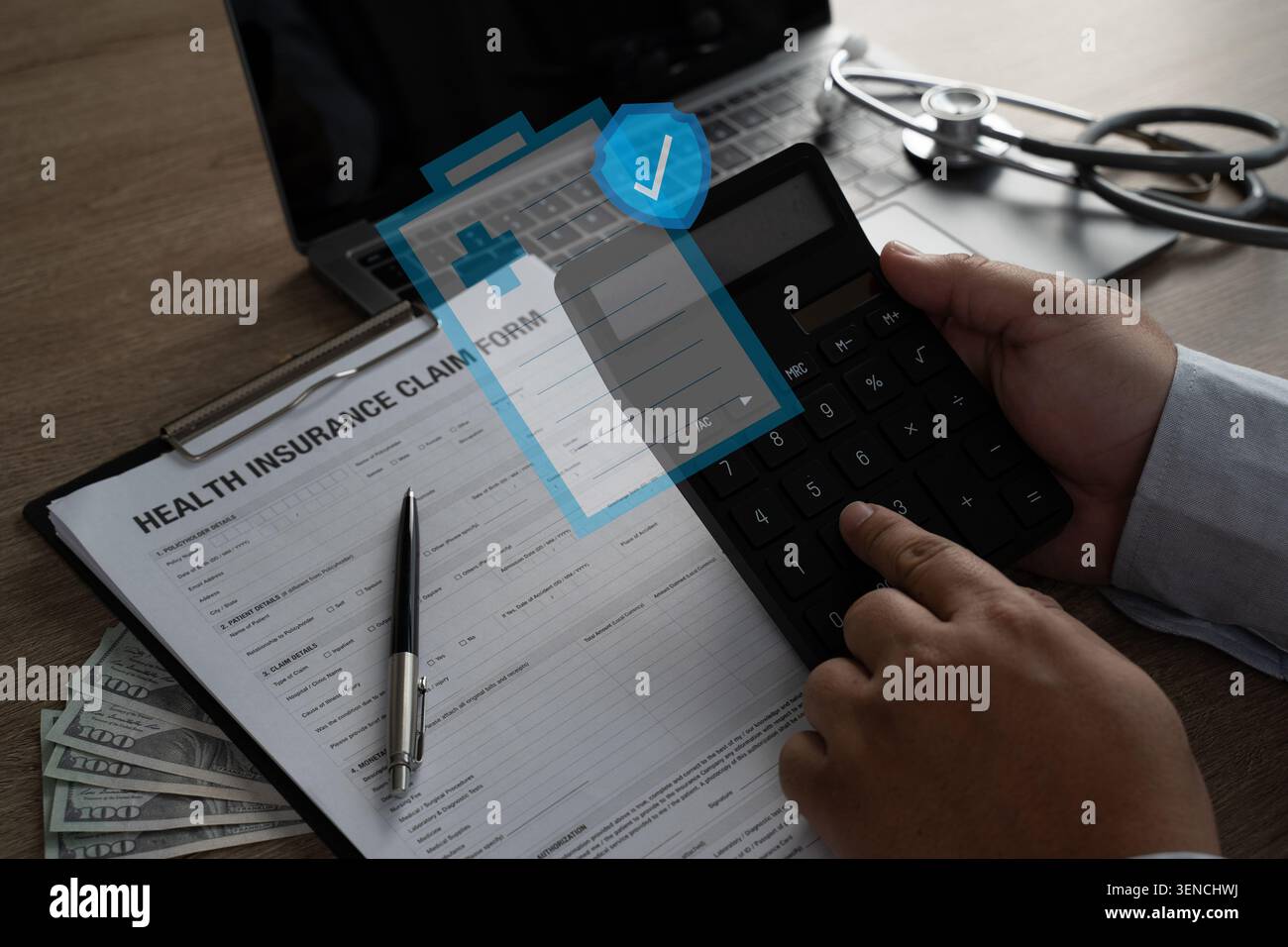 Mani utilizzando una calcolatrice sopra un modulo di richiesta di assicurazione sanitaria con contanti, laptop, e stetoscopio, illustrando il calcolo delle spese mediche, assicurazione r Foto Stock
