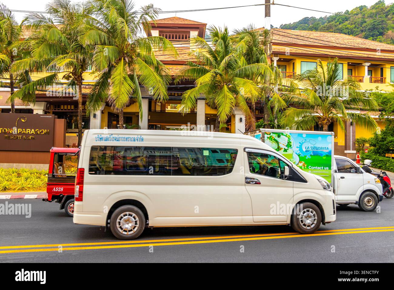 Minibus turistico che guida lungo vivaci strade tropicali trasportando i visitatori tra le destinazioni di Patong Beach, nel distretto di Kathu, nella provincia dell'isola di Phuket Foto Stock