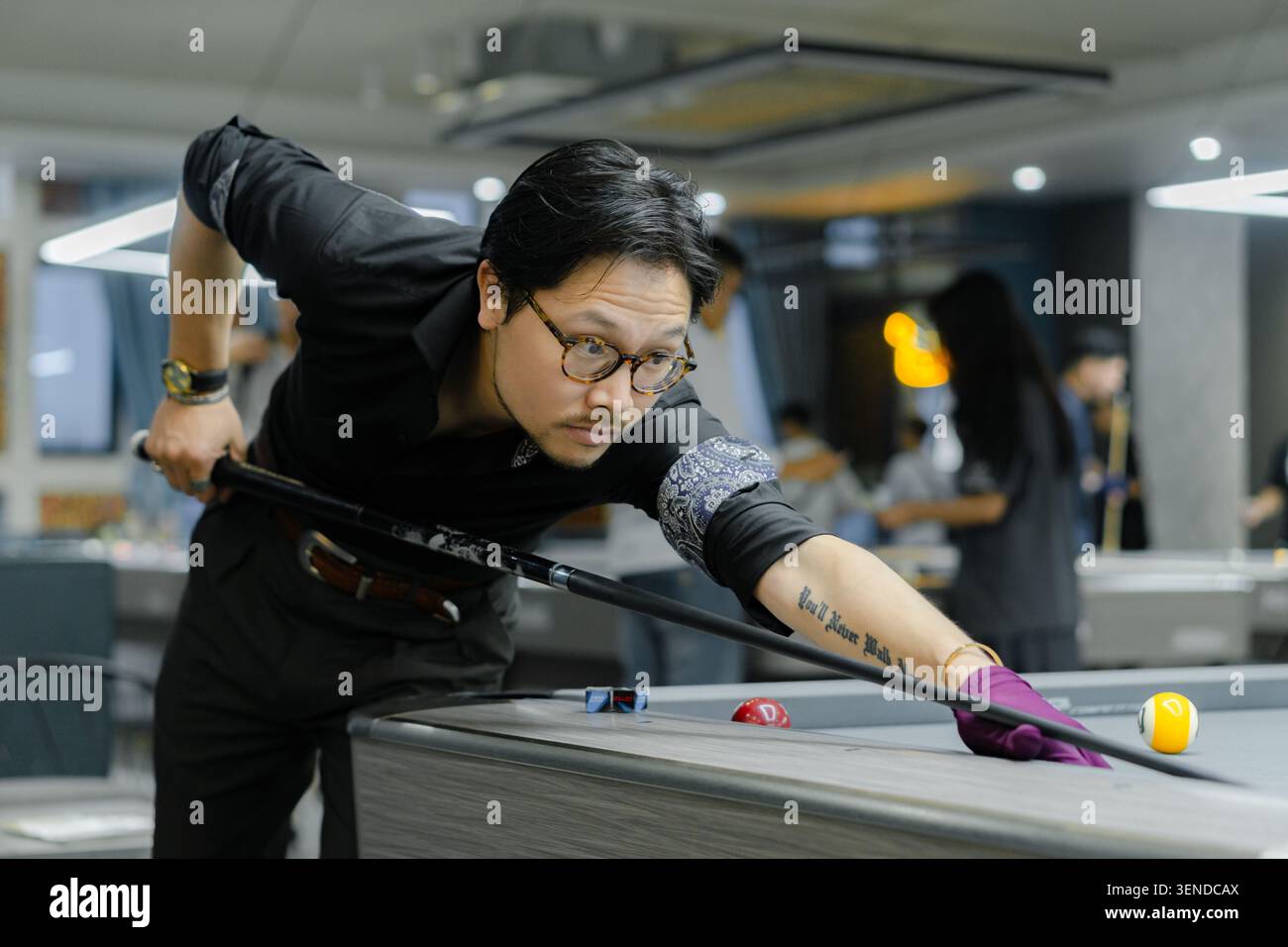Tiro di mira da giocatore professionista della piscina durante la partita di biliardo. Giocatore di biliardo competitivo incentrato su Precision Shot Foto Stock