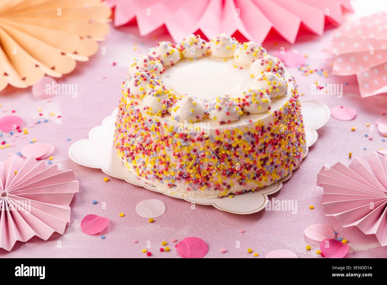 Deliziosa torta panna per la festa di compleanno con decorazioni in carta rosa Foto Stock