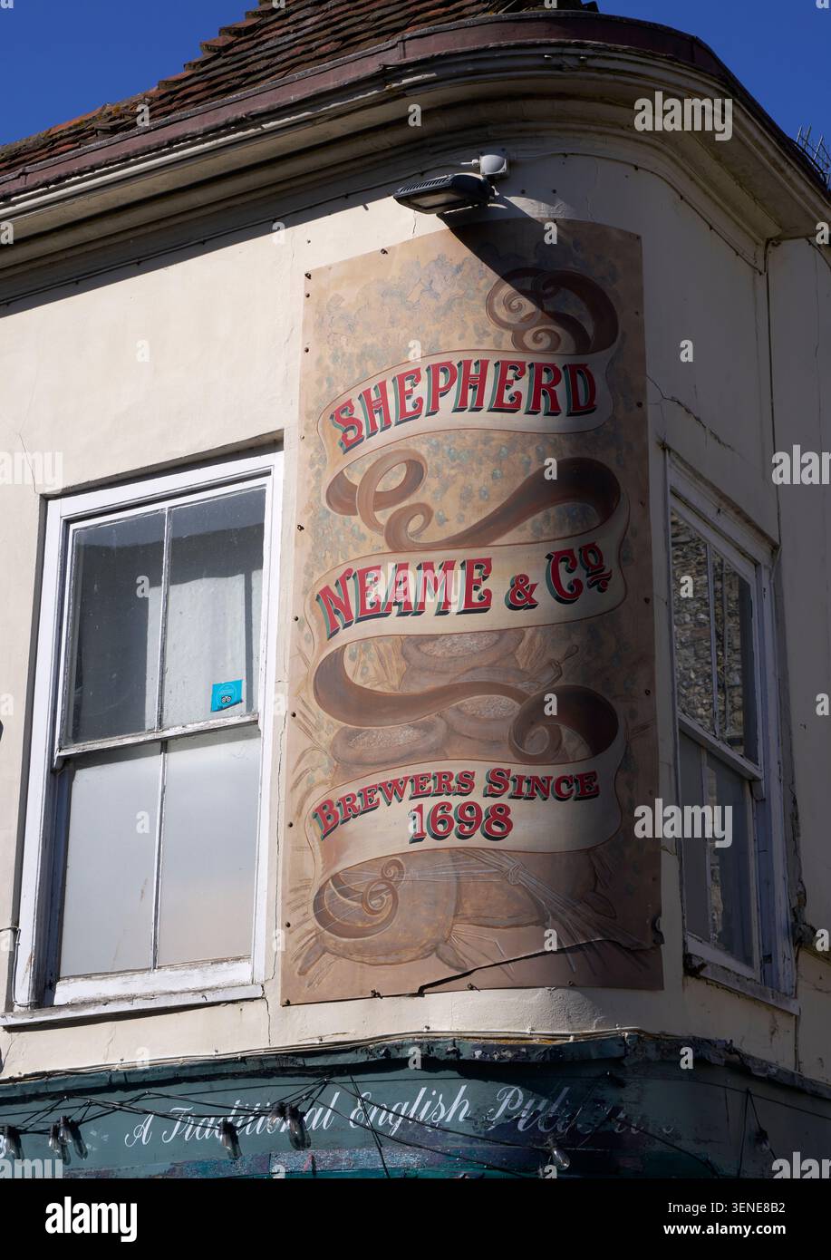 Una pubblicità di Shepherd Neame & Co all'angolo del pub Cricketers in St Peter's Street, Canterbury Foto Stock
