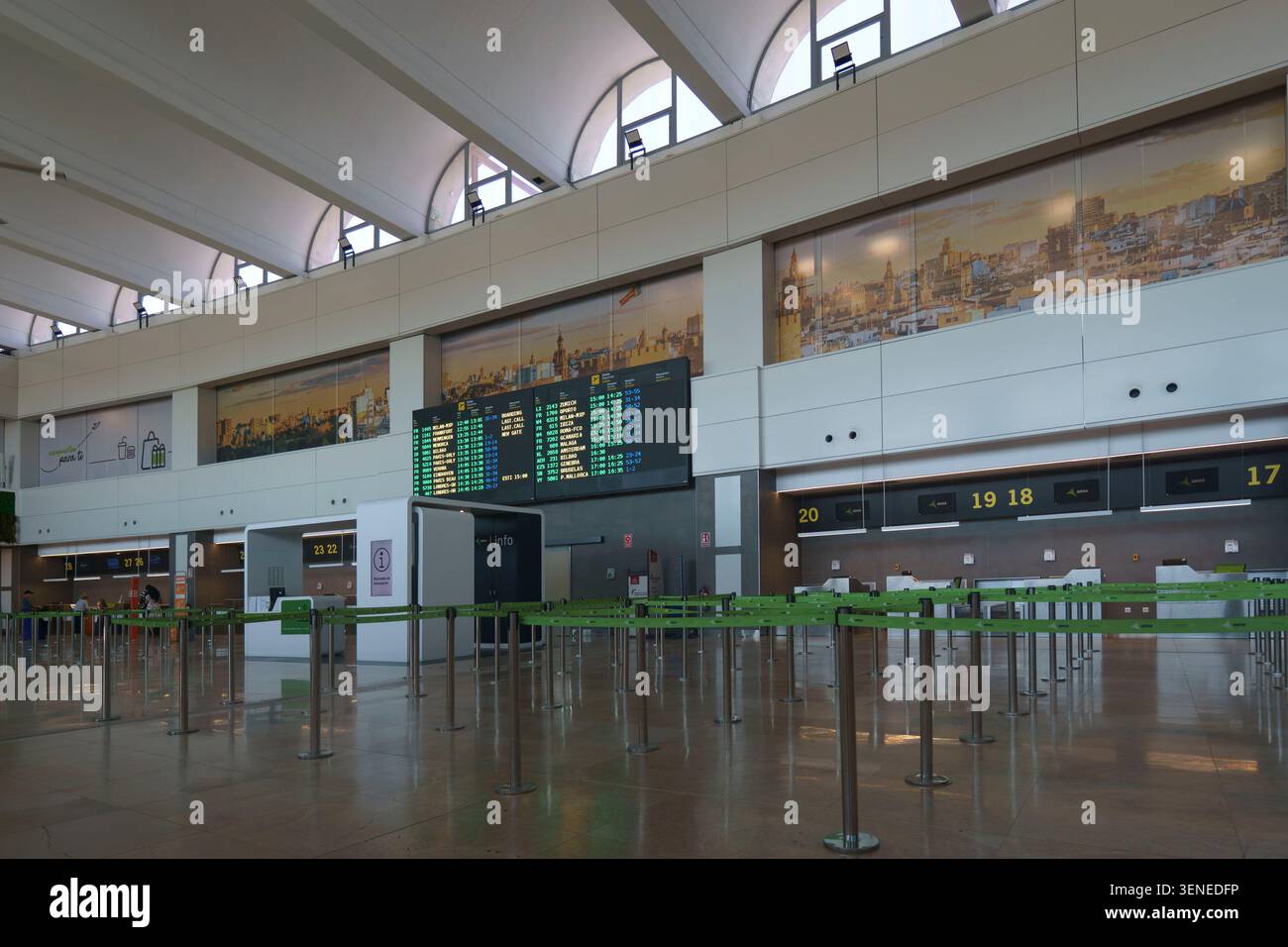 Banchi di check-in vuoti e tabellone informativo per la partenza dei voli all'interno della sala terminal principale dell'aeroporto di Valencia in Spagna Foto Stock