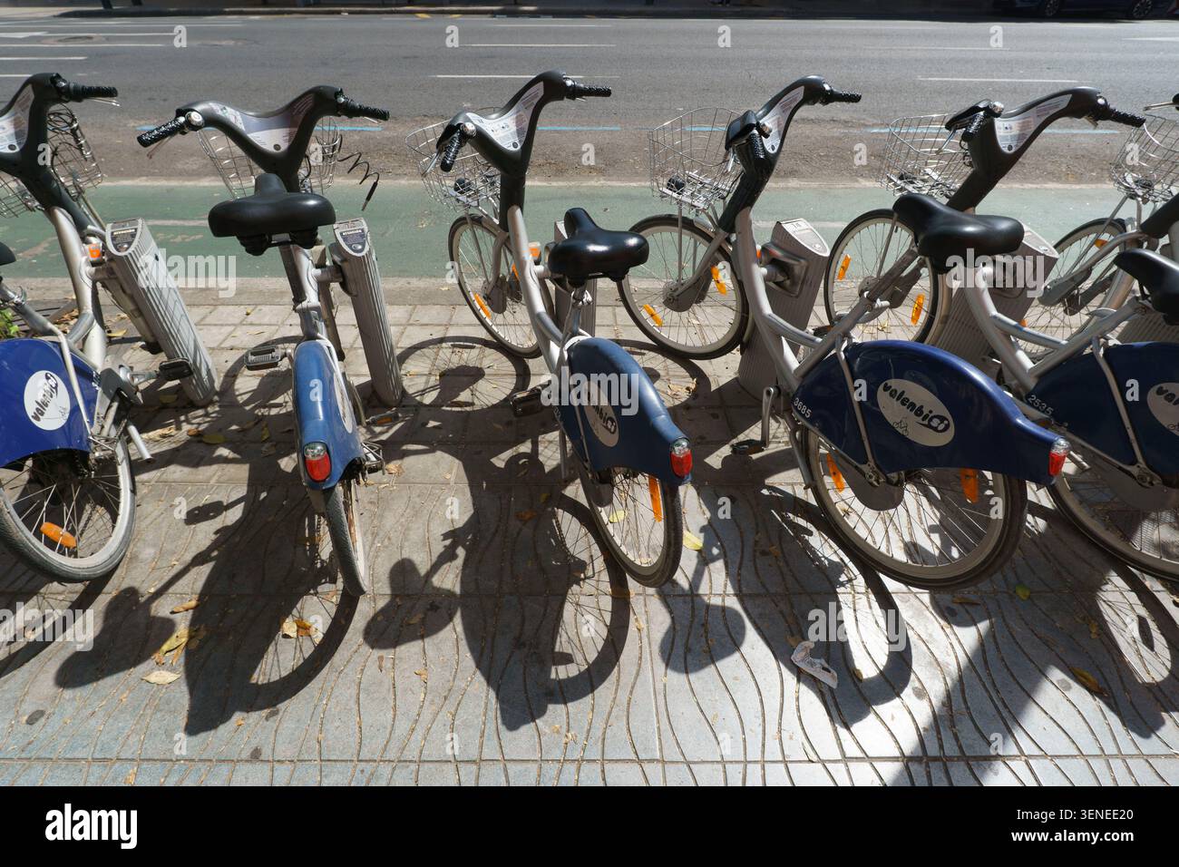 Stazione pubblica di Valenbisi per la condivisione delle biciclette su un marciapiede soleggiato a Valencia, Spagna Foto Stock