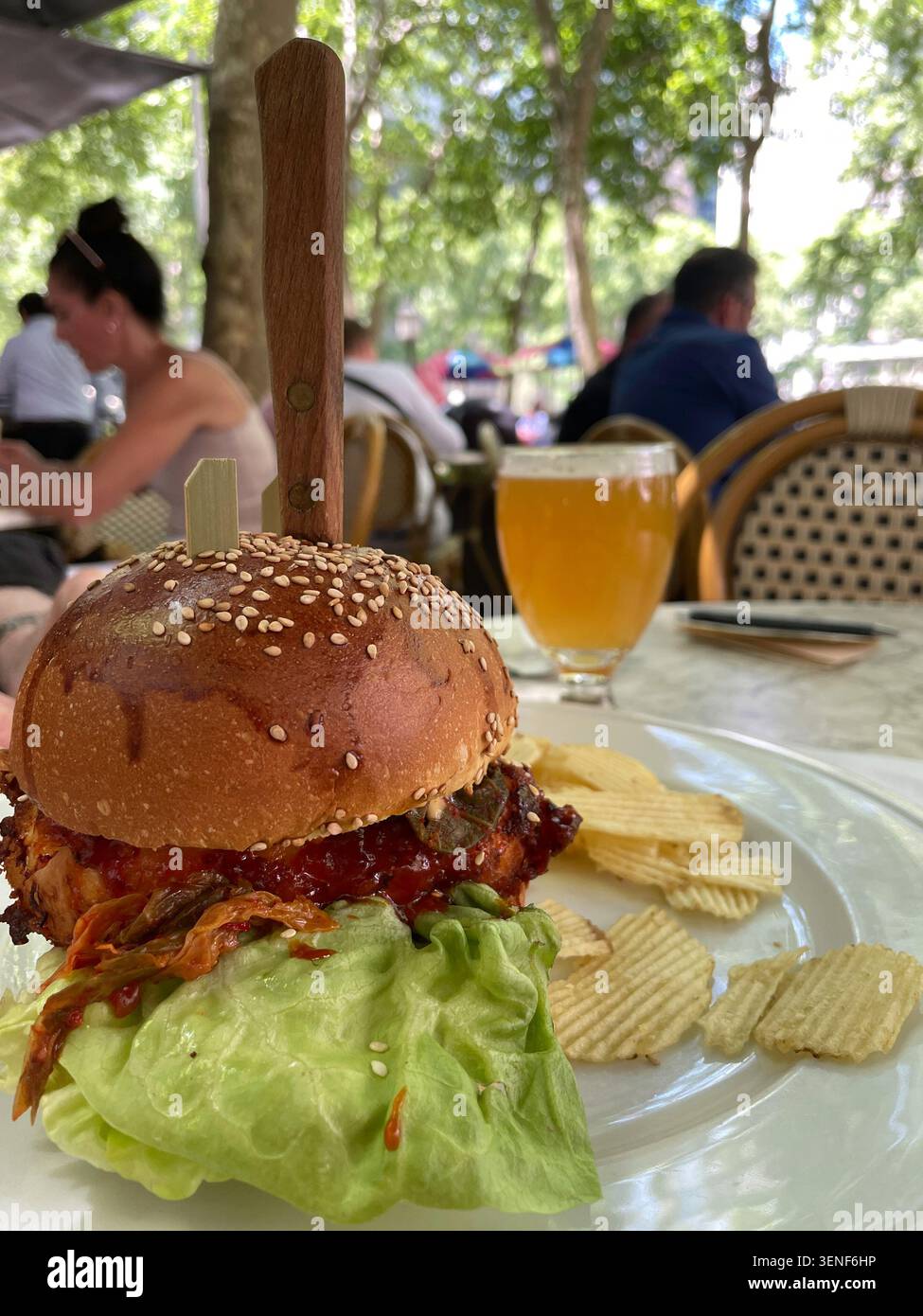 Primo piano di Spicy Korean Fried Chicken, Sandwich Outdoor Dining al Bryant Park Grill Restaurant's BP Cafe, 2026, NYC, USA - Immagine stock catturata con smartphone