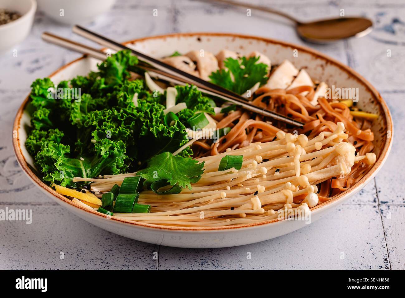 Zuppa asiatica di noodle di miso ramen con pollo, funghi enoki, cavolo. Foto Stock