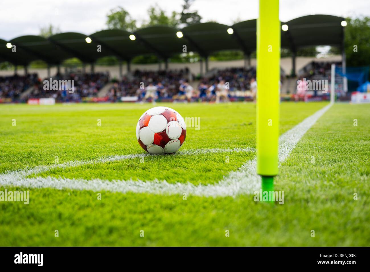 Calcio appoggiato vicino alla bandiera d'angolo su un campo verde prima di un set-piece durante una partita di calcio in uno stadio Foto Stock
