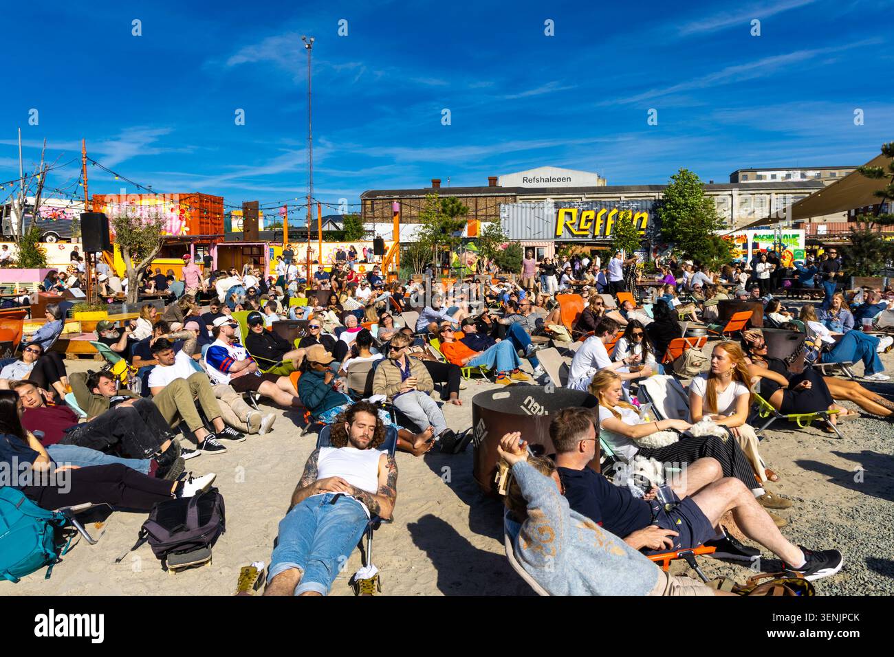 Persone che si rilassano in una giornata di sole alla spiaggia Reffen Street Food Market, Refshaleøen Harbour, Copenhagen, Danimarca Foto Stock