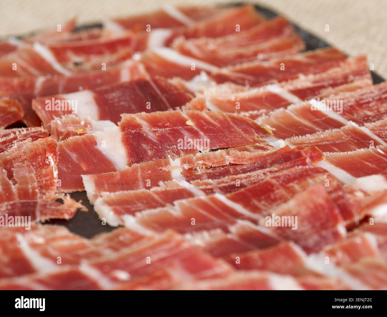 Primo piano di prosciutto stagionato a fette organizzato su un tabellone, tipico della salumeria europea, in Francia. Foto Stock