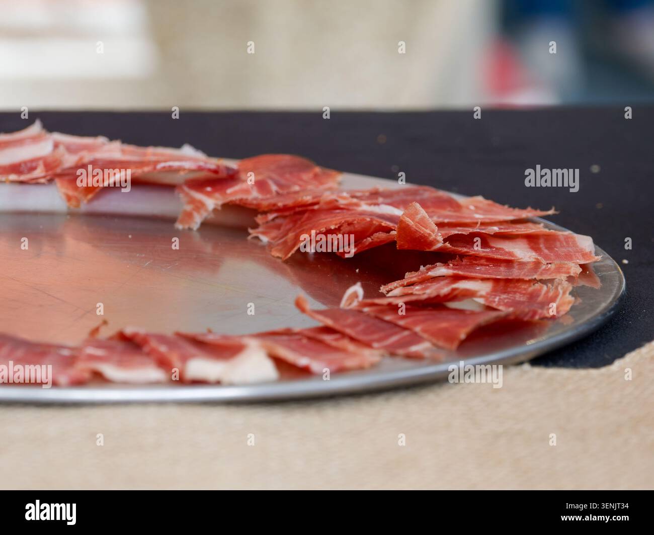 Primo piano di prosciutto stagionato a fette organizzato su un tabellone, tipico della salumeria europea, in Francia. Foto Stock