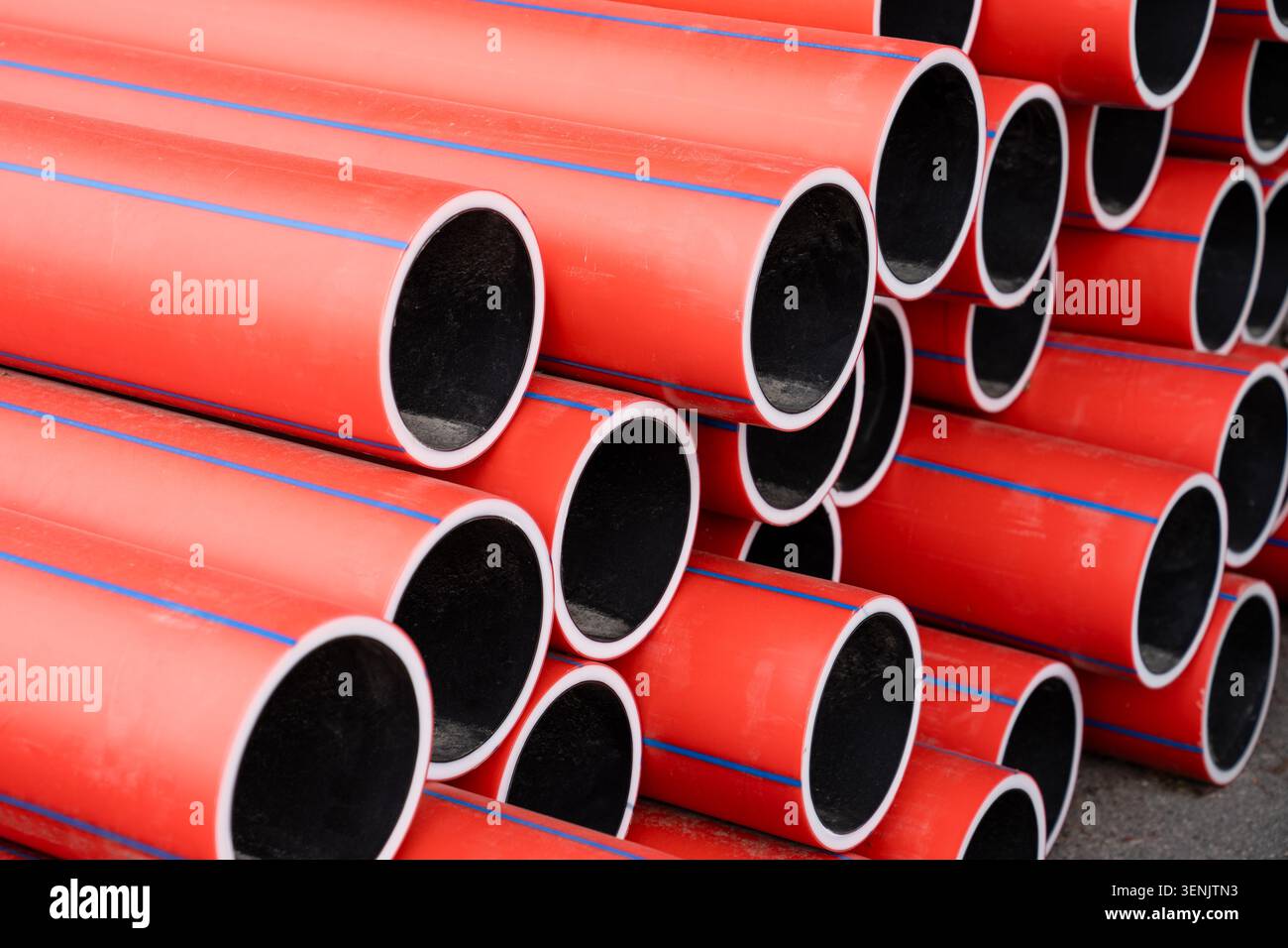 Primo piano dei nuovi tubi dell'acqua in PVC rosso. Impianto di alimentazione dell'acqua e sostituzione programmata dei tubi. Foto Stock
