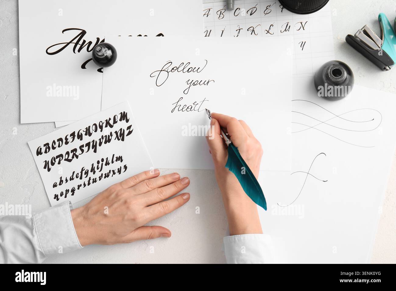 Arte calligrafica creativa con penna e inchiostro di piume, pratica di scrittura a mano, citazione ispiratrice su carta bianca Foto Stock