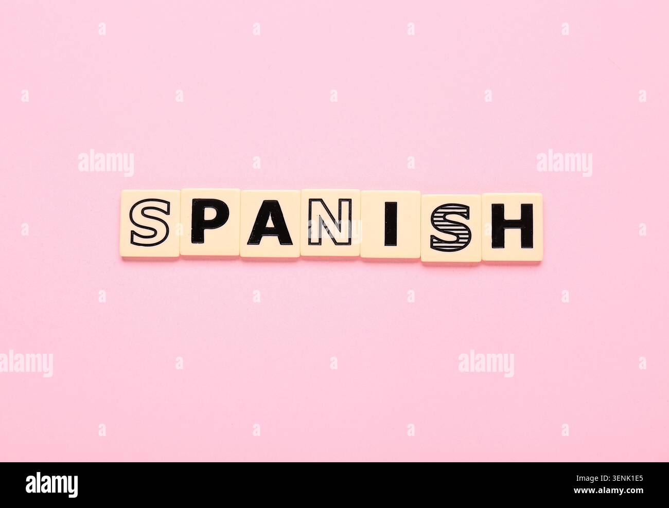 Apprendimento della lingua spagnola con mattonelle codificabili su sfondo rosa, istruzione e comunicazione, studio delle lingue straniere e scambio culturale Foto Stock