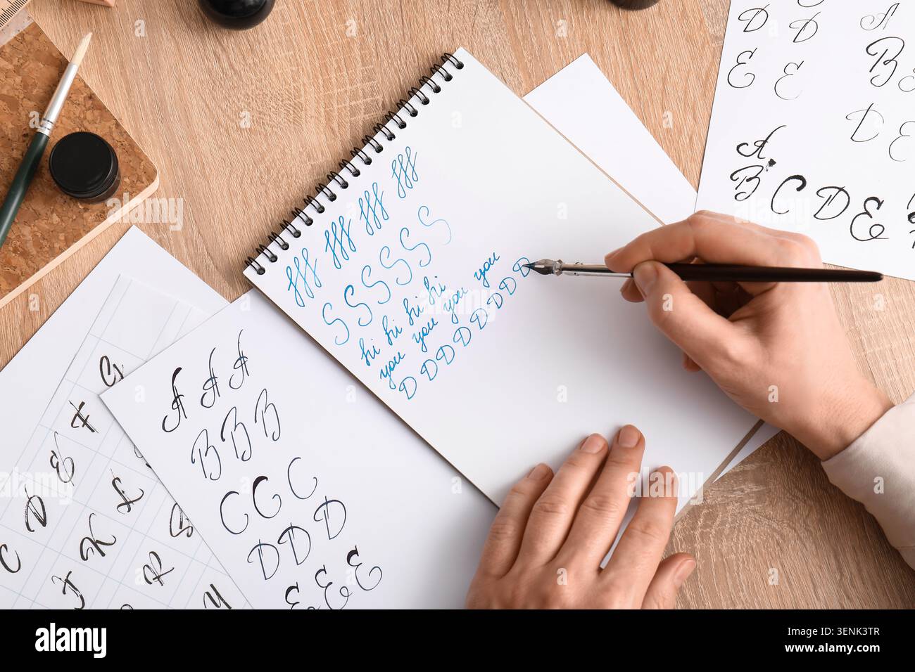 Pratica calligrafica con pennarello e inchiostro su carta, imparando la scrittura elegante e le abilità artistiche, vari fogli di pratica con inchiostro nero al Foto Stock