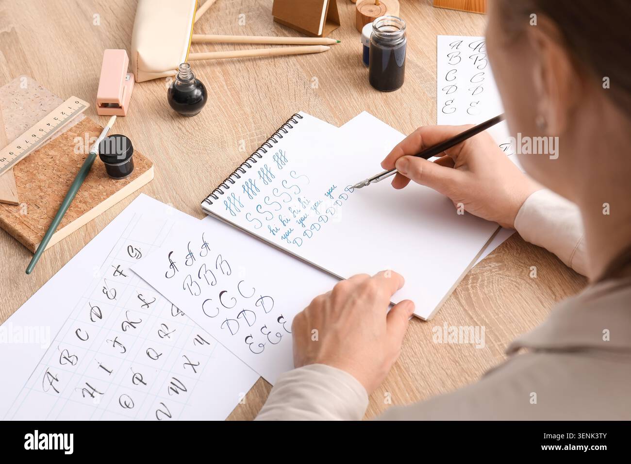 Pratica calligrafica con pennarello e inchiostro su carta, imparando la scrittura elegante, l'hobby creativo e l'espressione artistica Foto Stock