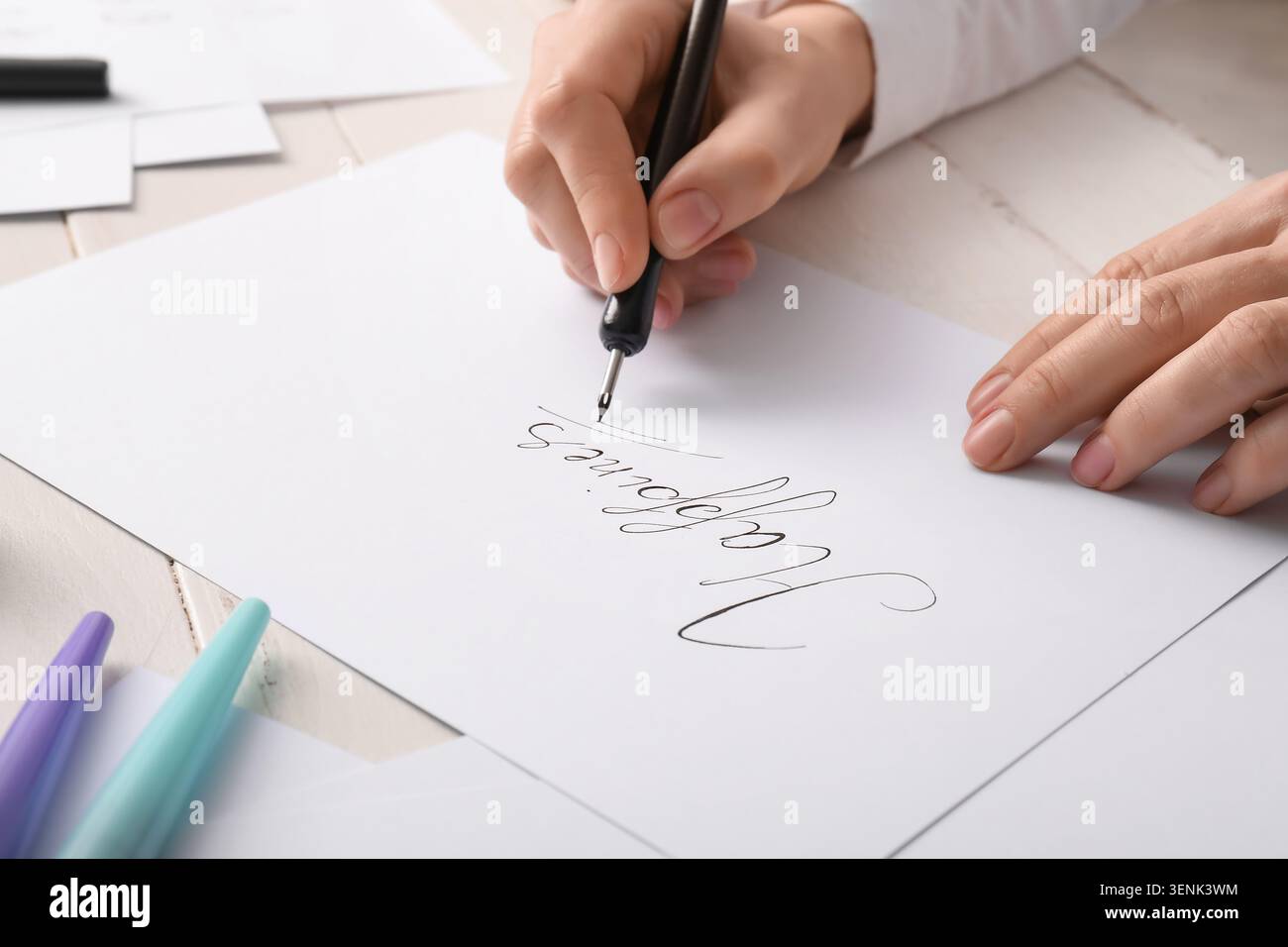 Processo creativo di scrittura calligrafica con pennarello su carta bianca, scrittura e creazione artistica a mano, lavoro dettagliato di un artista focalizzato sulla creazione Foto Stock