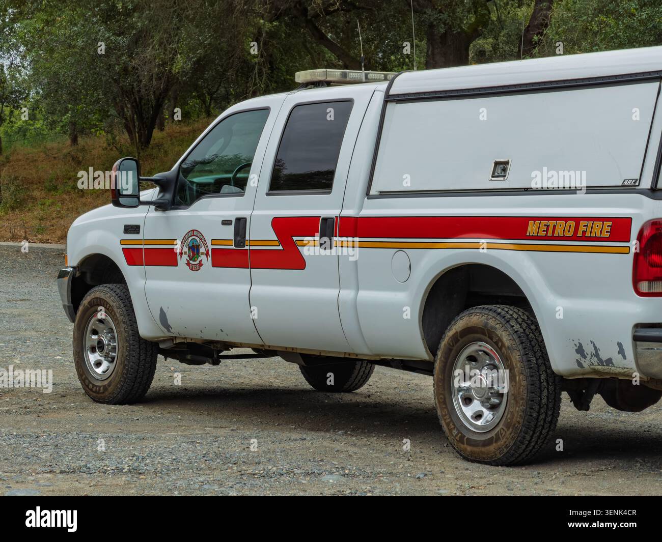 SACRAMENTO, CA - 28 MAGGIO 2026: Un camion bianco del distretto dei vigili del fuoco metropolitano di Sacramento con strisce rosse e gialle è parcheggiato su un sentiero sterrato Foto Stock