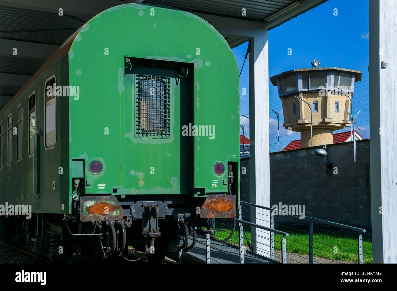 Uno storico veicolo per il trasporto di prigionieri è esposto sul terreno del memoriale di Berlino-Hohenschönhausen, la torre di guardia della prigione Stasi sullo sfondo. Foto Stock