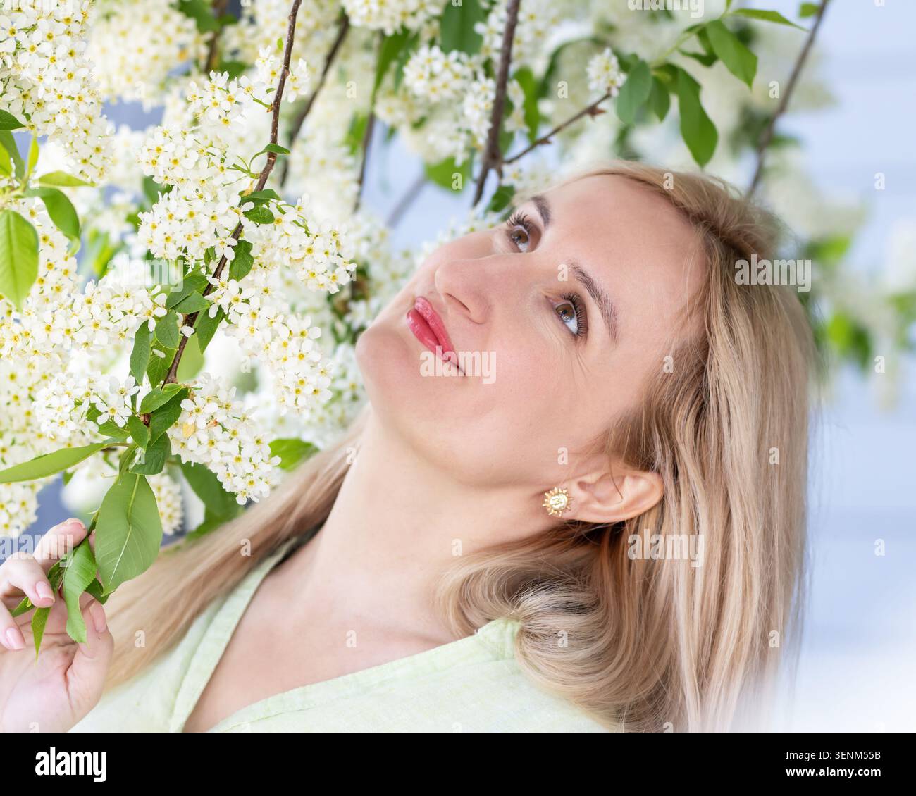 Persone vere, semplice e autentica bellezza naturale di una donna bionda caucasica con un sorriso sincero che indossa una camicia di cotone leggero. Scena in un parco primaverile al b Foto Stock