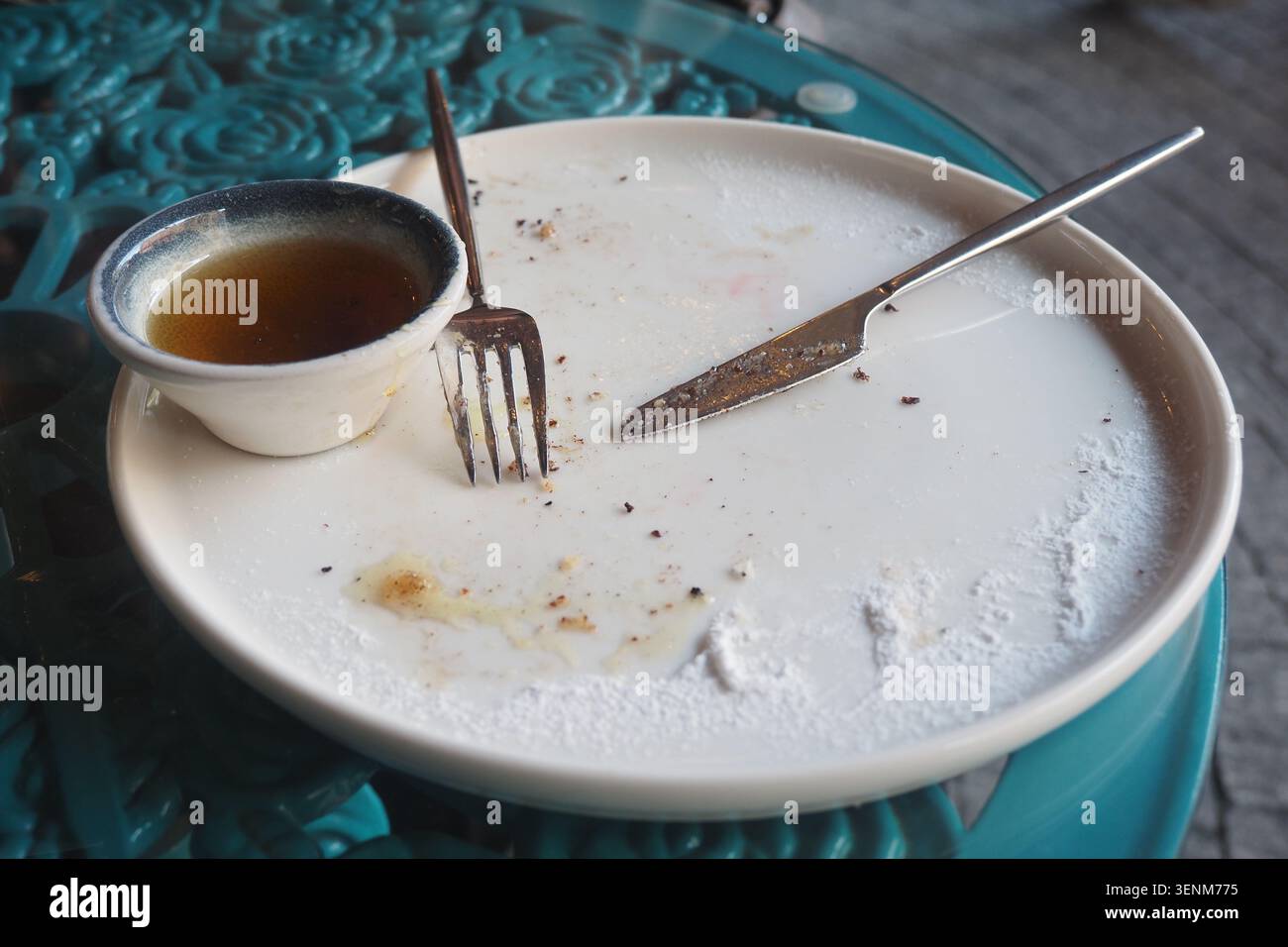 Svuotate il piatto e gli utensili su un tavolo dopo un pasto Foto Stock