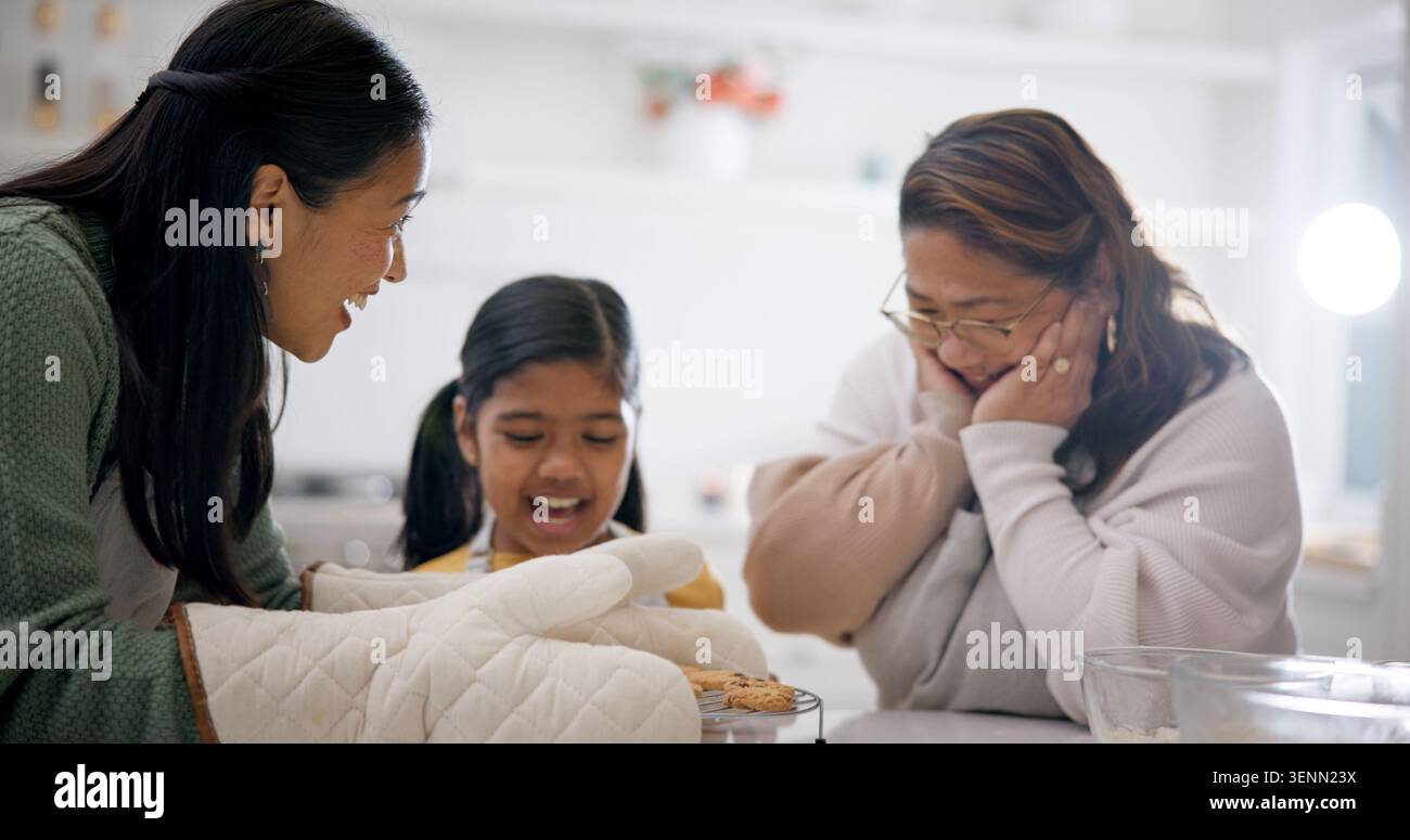Sorpresa, famiglia e biscotti a casa per cucinare, imparare e incollare con prelibatezze fatte in casa. Mamma, nonna e biscotti in cucina con Foto Stock