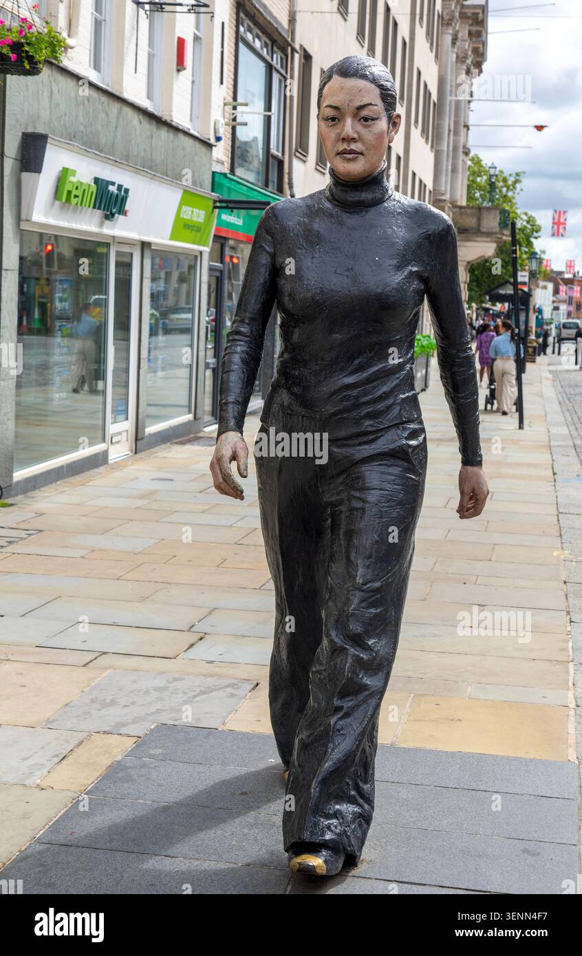 Opera di donna che cammina scultura in bronzo dipinta da Sean Henry 2017 nel centro della città, Colchester, Essex, Inghilterra, Regno Unito Foto Stock