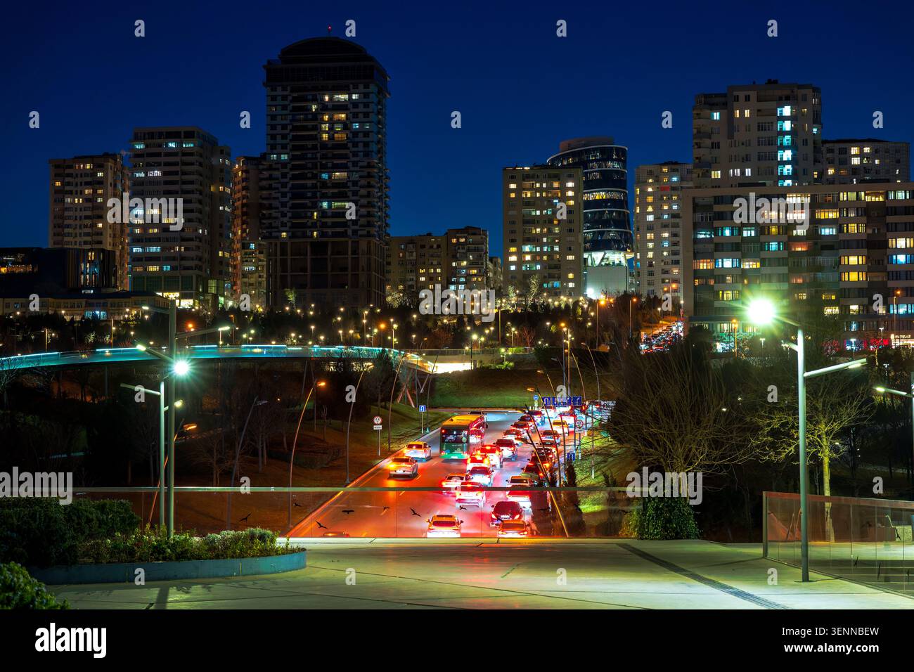 Vista notturna del traffico di Fuzuli Street e delle torri residenziali illuminate viste dal Parco Merkezi. Baku, Azerbaigian. Foto Stock