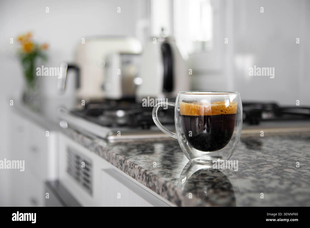 Caffè espresso in una tazza di vetro a doppia parete sul banco della cucina Foto Stock