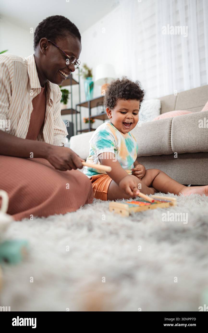 Nonna e nipotino che giocano allo xilofono, si legano, si divertono Foto Stock