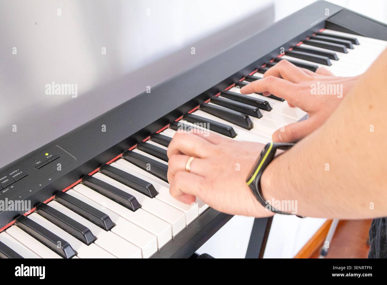 Primo piano di mani che suonano la tastiera elettronica del pianoforte. Dita sui tasti, pratica musicale, apprendimento degli strumenti, creatività, hobby ed espressioni artistiche c Foto Stock
