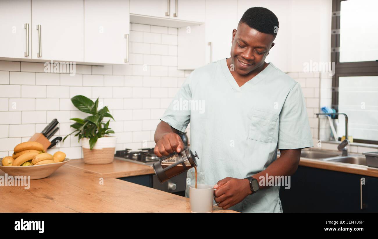 Operatore sanitario versare caffè in cucina durante la routine mattutina rilassata a casa Foto Stock
