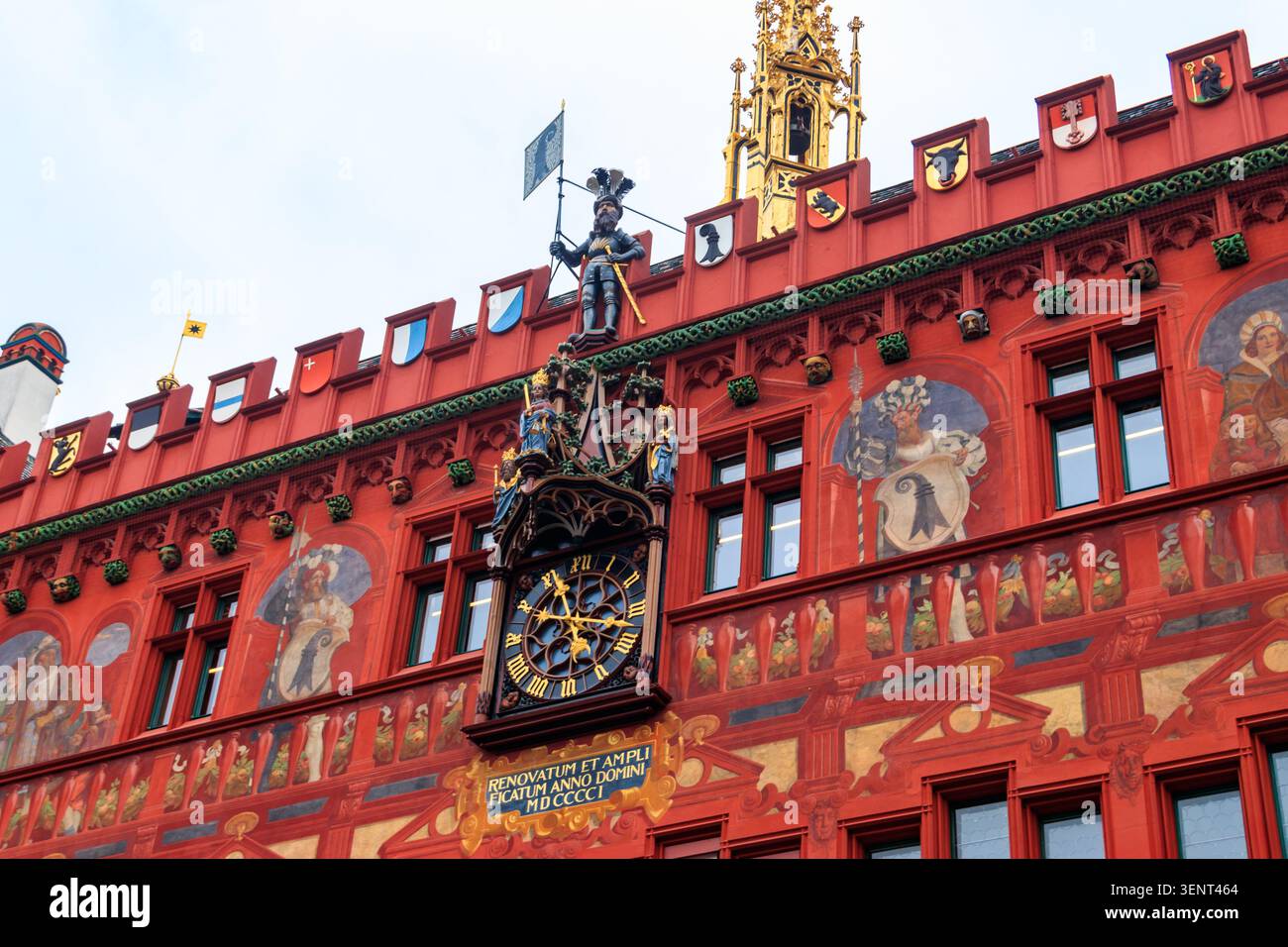 Primo piano del municipio rosso con orologio, dipinti e ornamenti a Basilea, Svizzera Foto Stock
