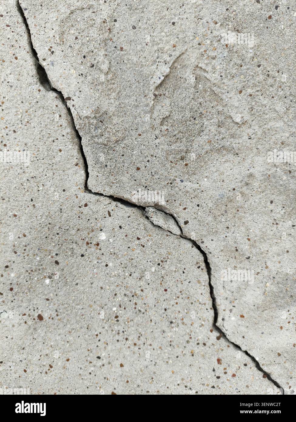 Una spaccatura diagonale irregolare su una superficie di cemento ruvido. Un vecchio muro di cemento rovinato, incrinato di un edificio. Distruzione dopo il terremoto. Copia spazio. R Foto Stock