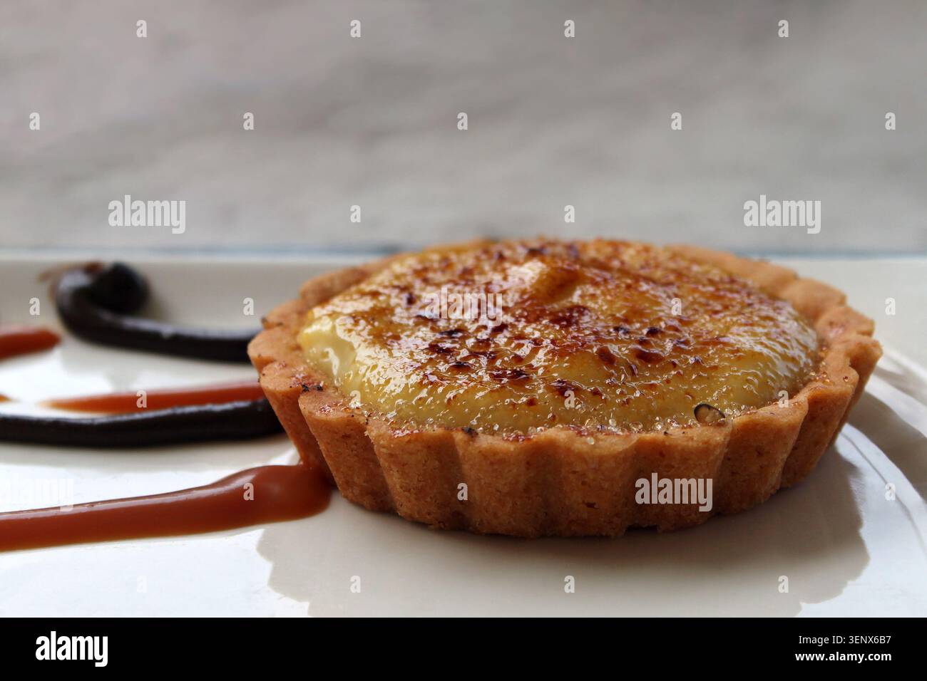 Una crostata piena di crema con crème brulee sulla parte superiore. Foto Stock