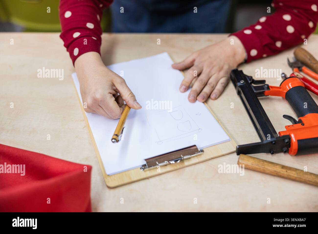 Persona che disegna il design della tappezzeria con gli attrezzi sul tavolo Foto Stock