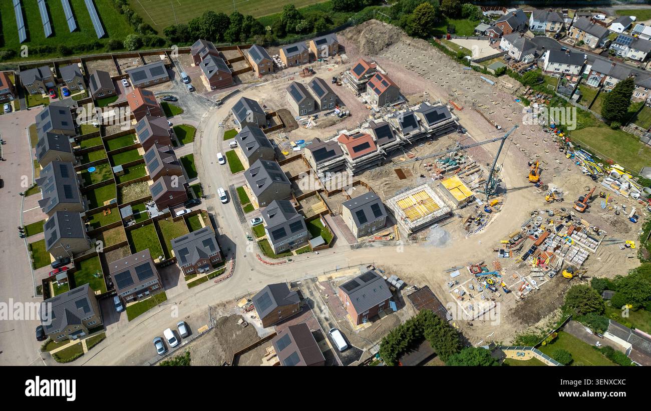 Una vista aerea che mostra un cantiere residenziale in fase di sviluppo, circondato da case completate e vegetazione a Noble Homes, a Kno Foto Stock