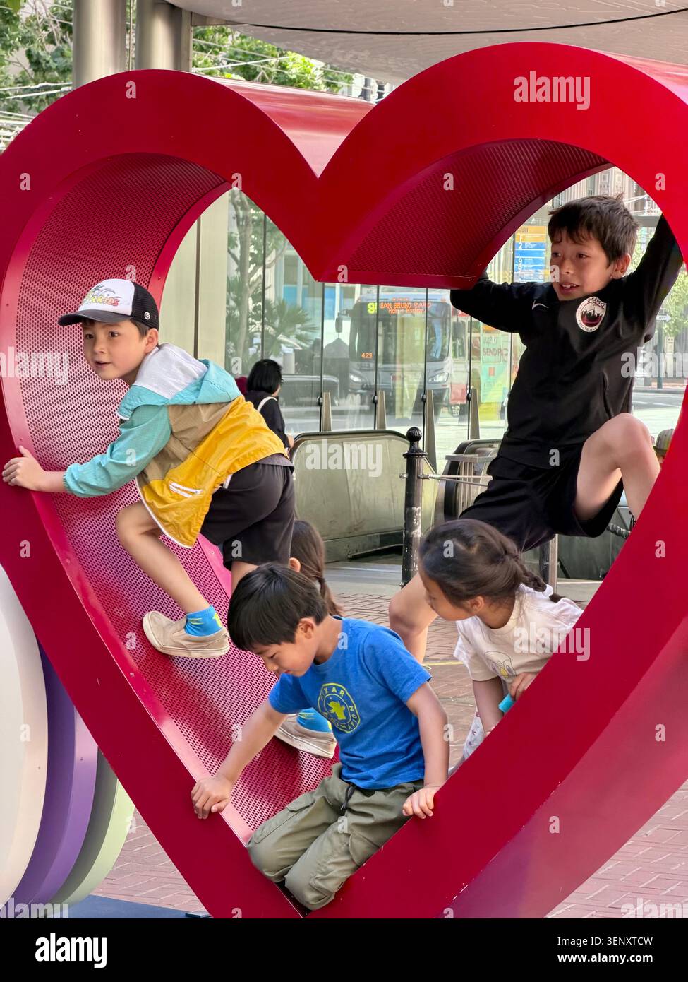 Ragazzi che suonano in una scultura del cuore nella sezione Embarcadero del centro di San Francisco, California Foto Stock