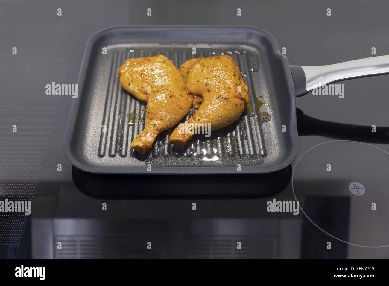 Due cosce di pollo in una padella Foto Stock