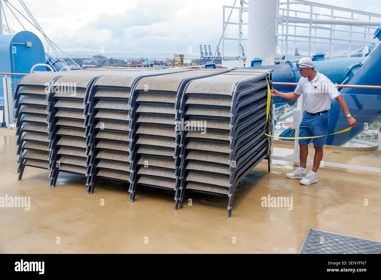Colon Panama, Norwegian Cruise Line NCL Joy Ship, membro dell'equipaggio, uomo adulto, sedie a sdraio impilabili, operazioni sul ponte, equipaggio della nave da crociera, manutenzione della nave, ra Foto Stock