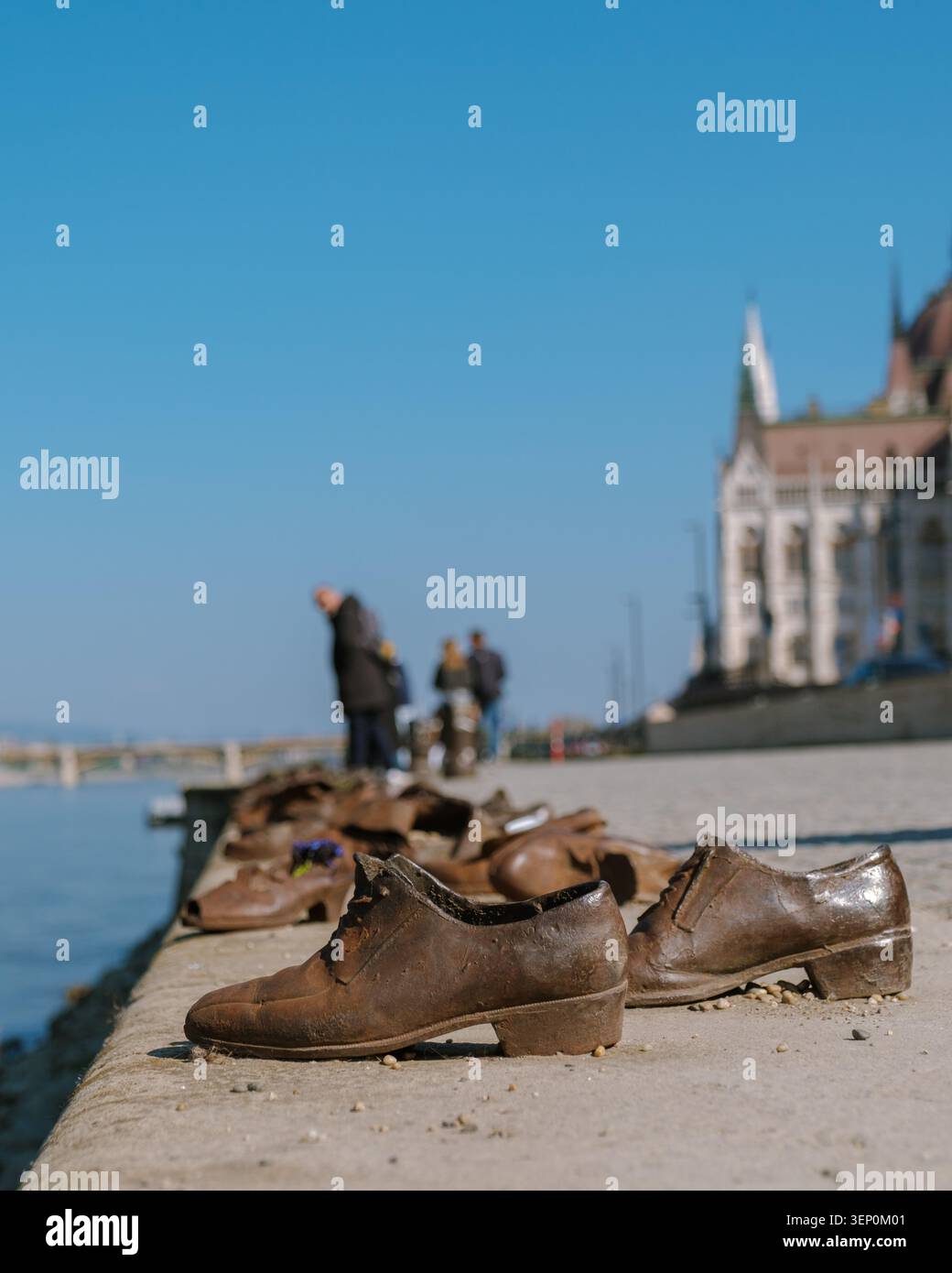 Budapest, Ungheria, offre una vista toccante delle vecchie scarpe poste lungo il Danubio, simboleggiando la storia e il ricordo. I visitatori passeggiano accanto a questo monumento artistico, che riflette sul passato. Foto Stock