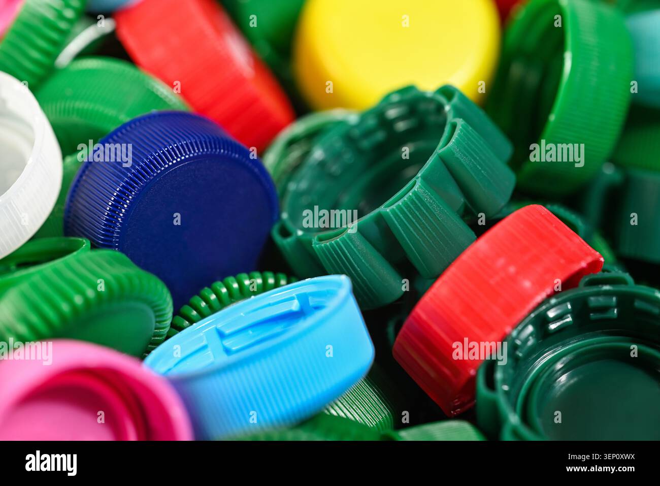 Primo piano di tappi colorati per bottiglie in plastica che rappresentano il riciclaggio, lo smistamento dei rifiuti e la gestione sostenibile della plastica. Concetto ambientale di circolare Foto Stock