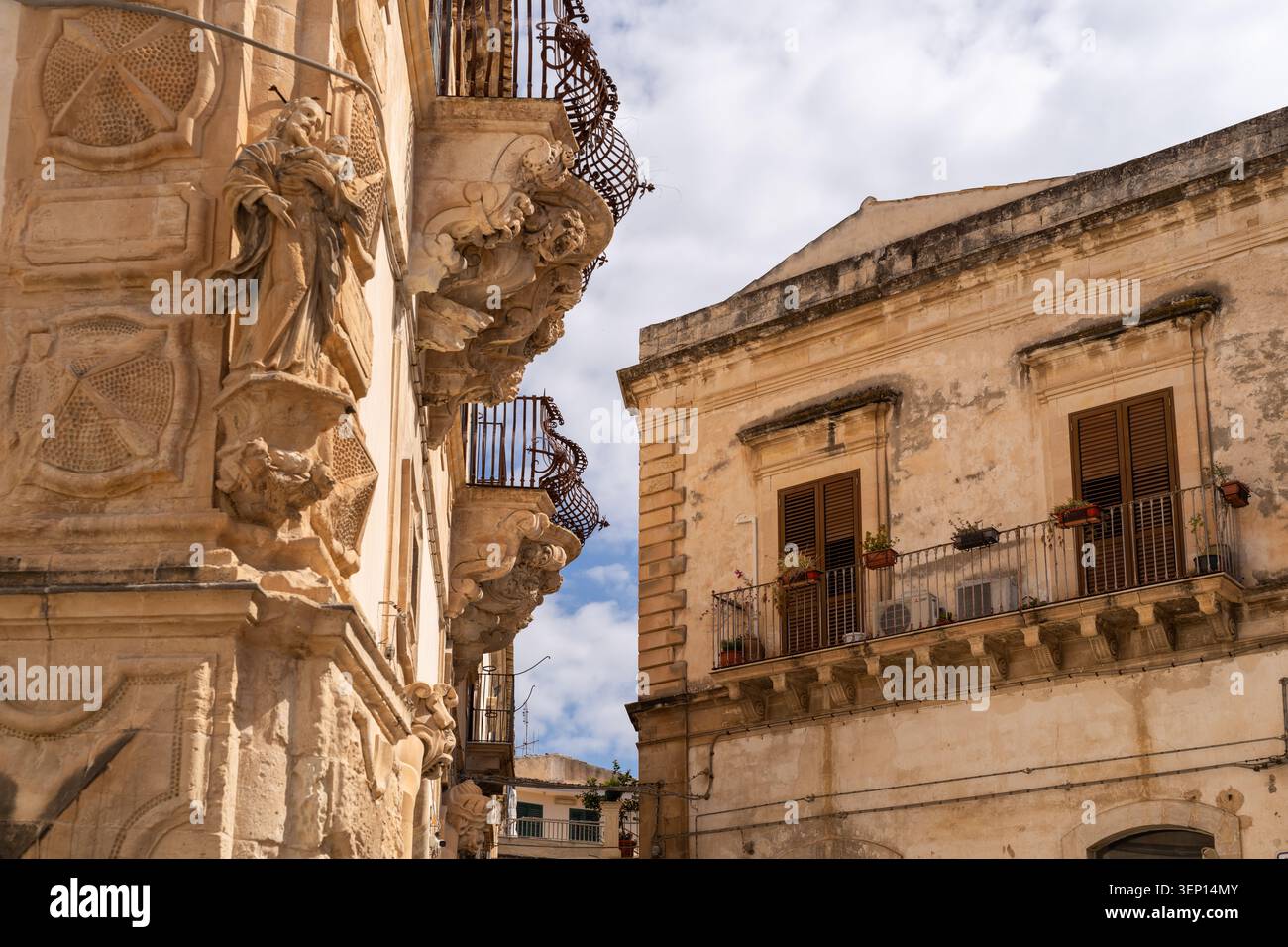 Statue in pietra ornate e balconi in ferro battuto su edifici barocchi storici a Scicli in Sicilia Foto Stock