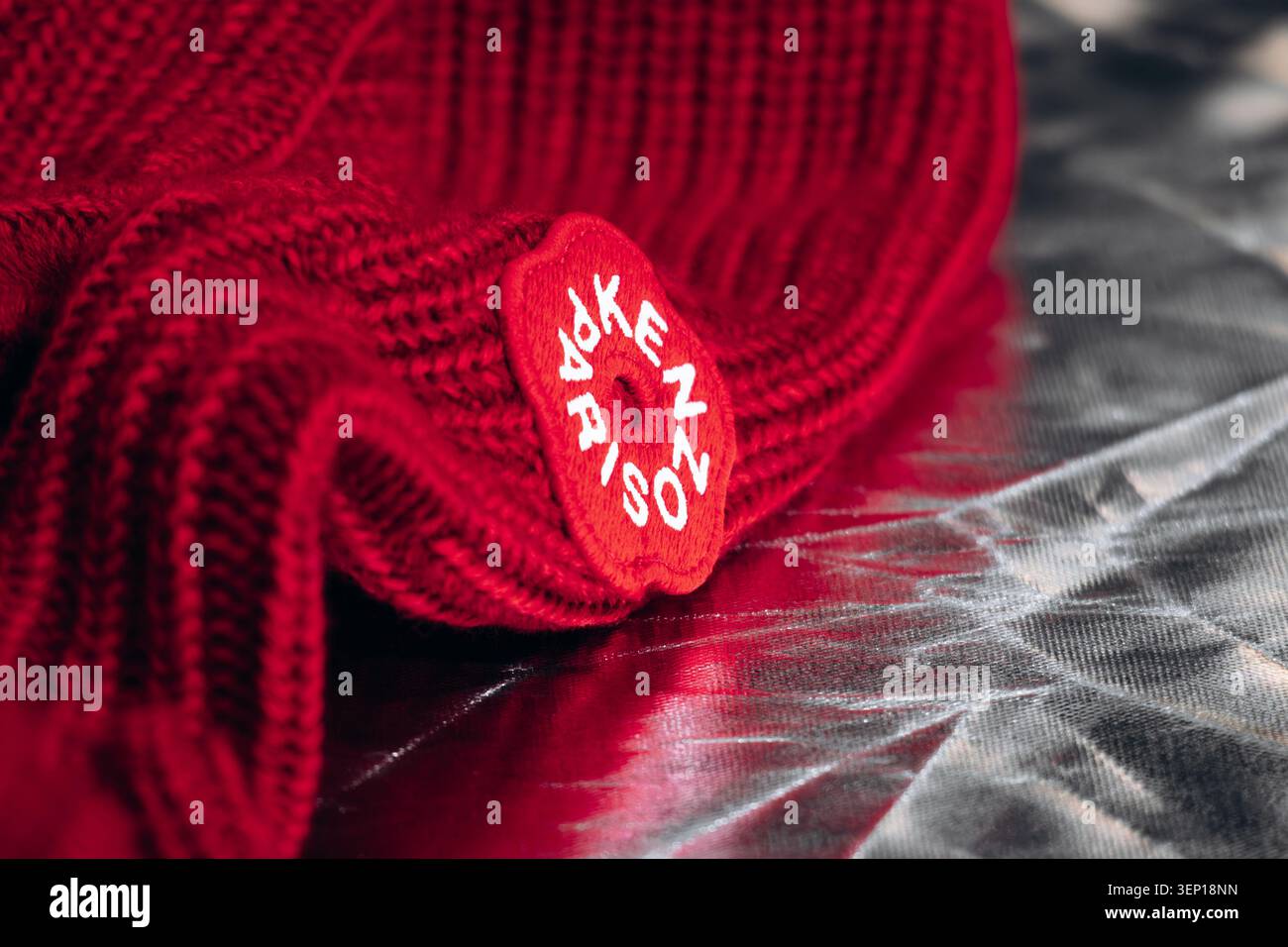 Nizza, Francia - 1 marzo 2026: Dettaglio ravvicinato di un capo in maglia Kenzo rosso con l'iconico logo floreale, che mette in risalto il design di lusso alla moda, Foto Stock
