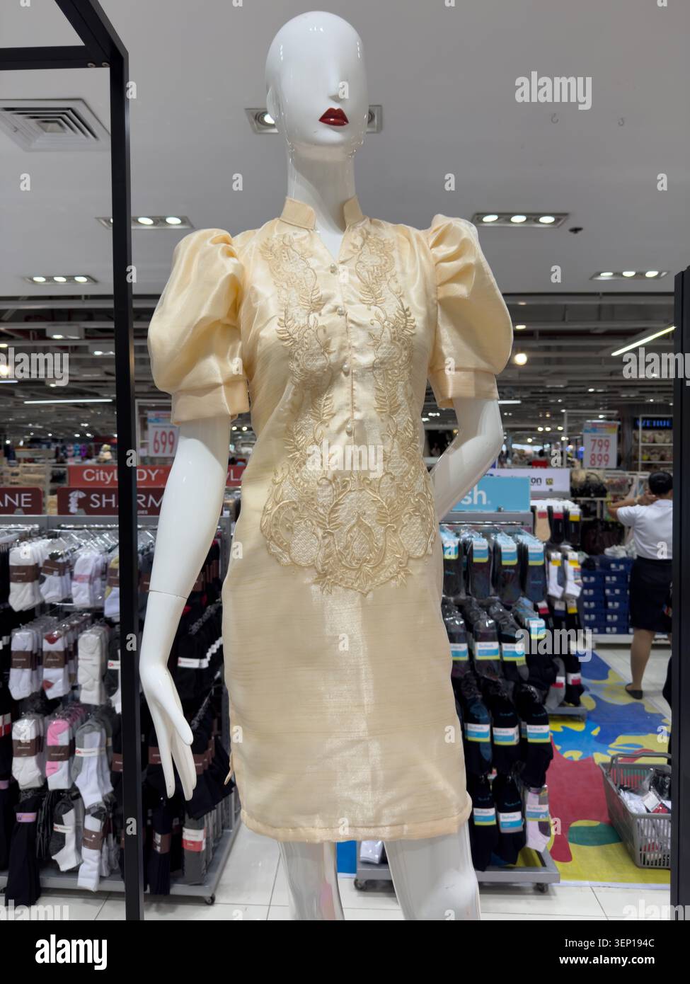 Elegante abito Filipiniana color crema con maniche a farfalla tradizionali e ricami esposti in un negozio al dettaglio filippino. - Immagine stock catturata con smartphone