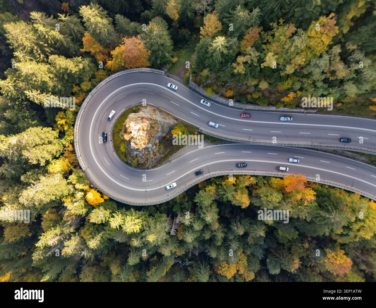Veduta aerea di una curva della strada di montagna con una croce su roccia in autunno Foto Stock