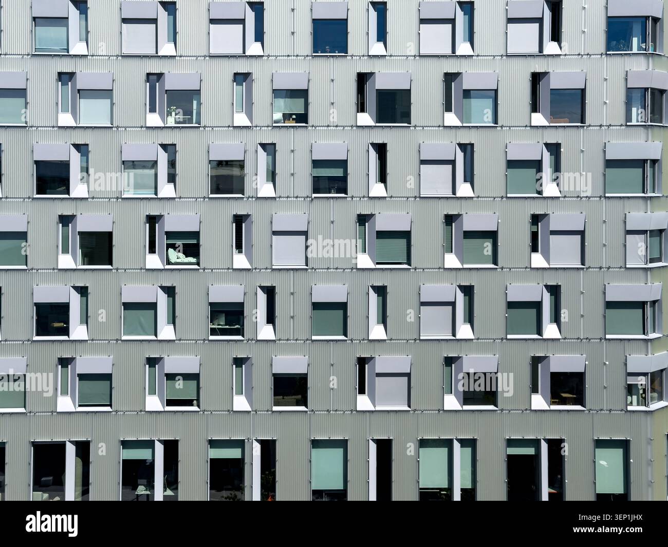 Facciata astratta di un moderno edificio per uffici con rivestimento metallico ondulato e serramenti geometrici ripetuti oslo norvegia Foto Stock