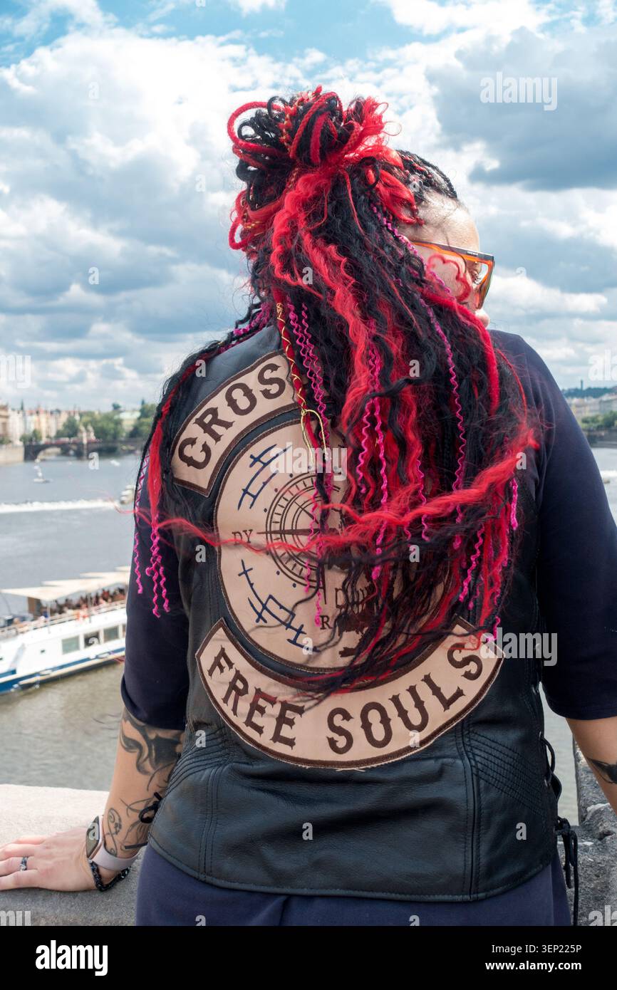 Donna con dreadlock neri e rossi che indossa un gilet in pelle Foto Stock